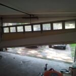 Broken garage door with visible damage in Houston TX