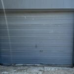 Old garage door in need of repair in Houston TX